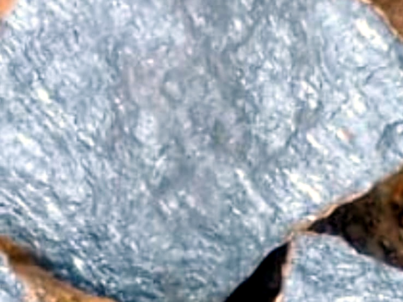 Close-up of freshly broken rock showing bright silver-grey metallic galena crystal faces