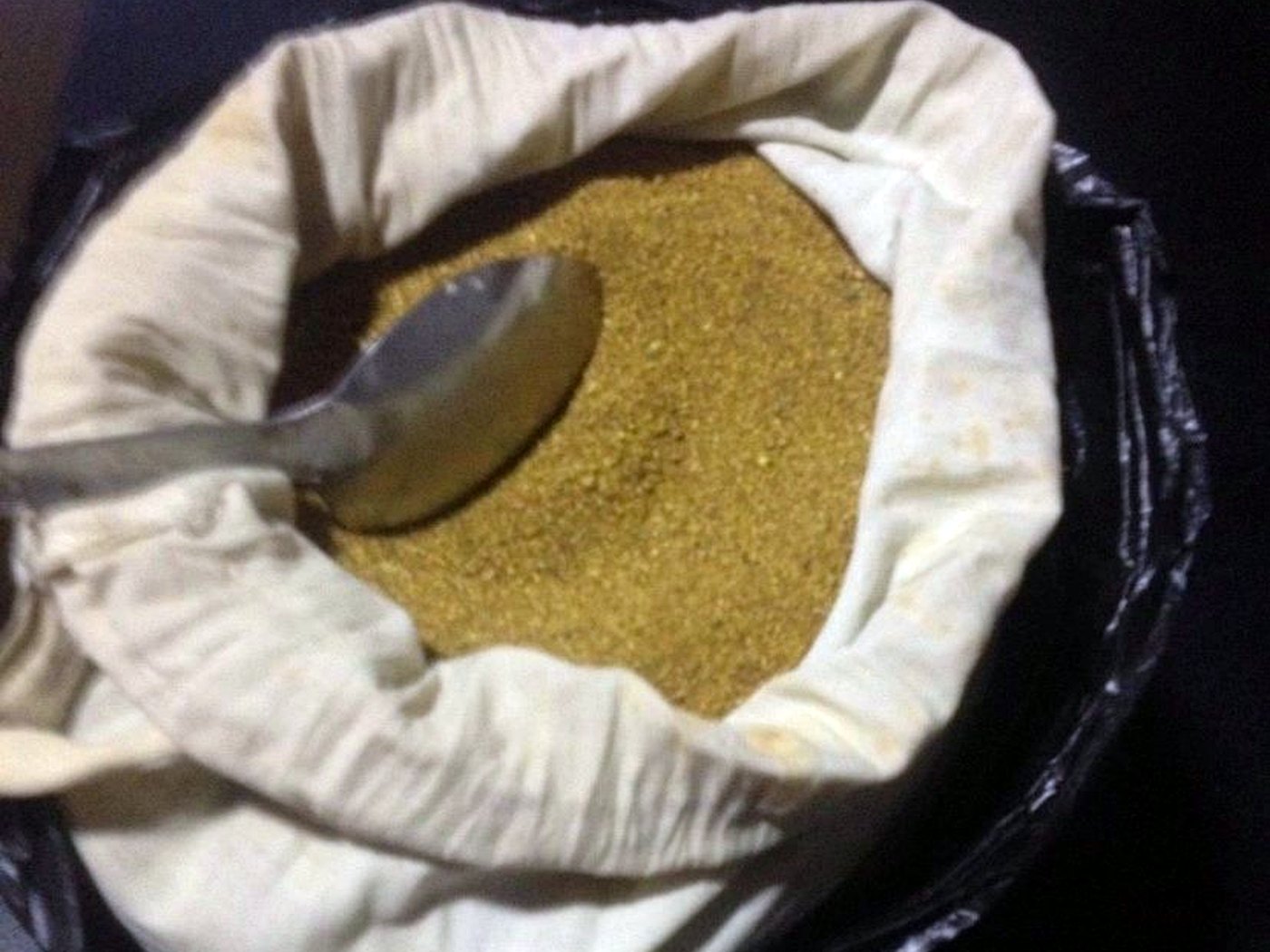 Fine golden gold dust concentrate in an open sample bag after mercury-free gravity separation